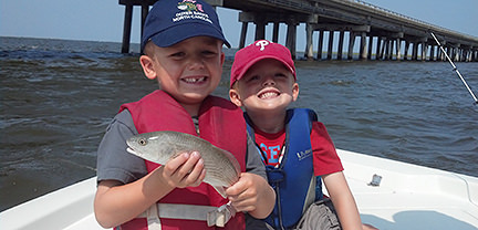 Two young boys with fish caught aboard Rock On Charters.