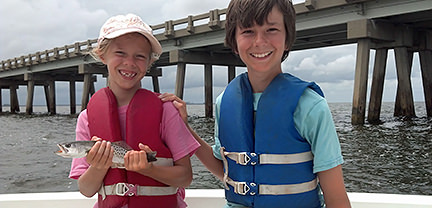 Two boys with fish caught aboard Rock On Charters.